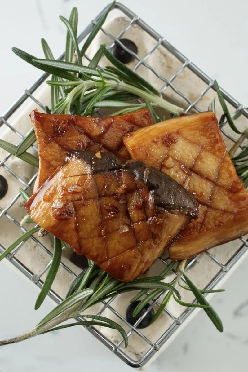Charcoal-seared oyster mushrooms on a small grill with rosemary