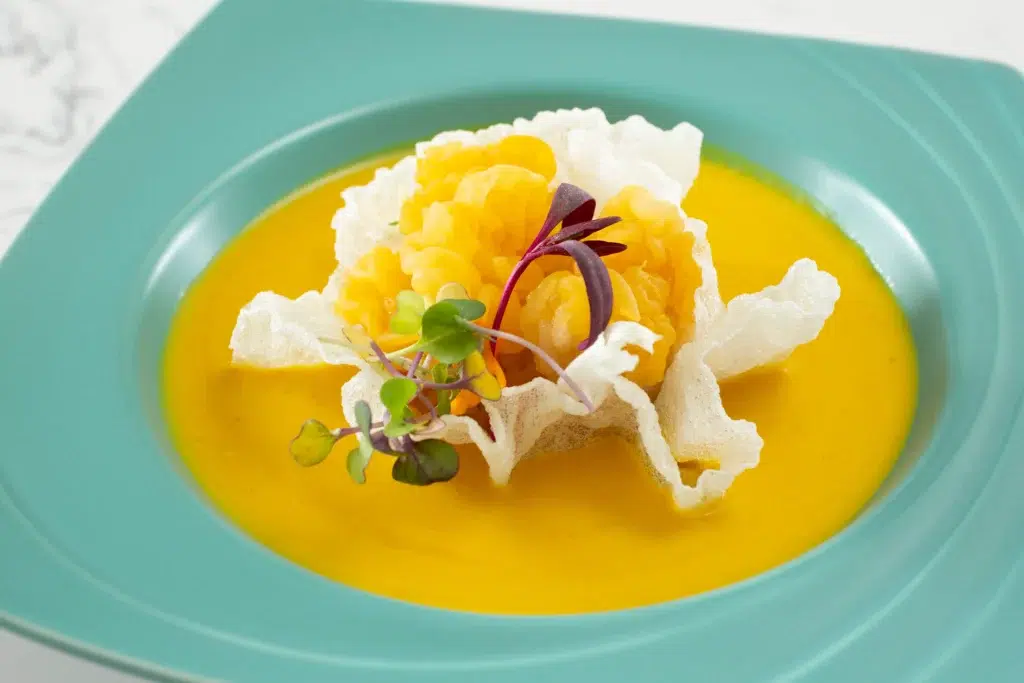 A vegan fine dining dish with pumpkin and golden ears.